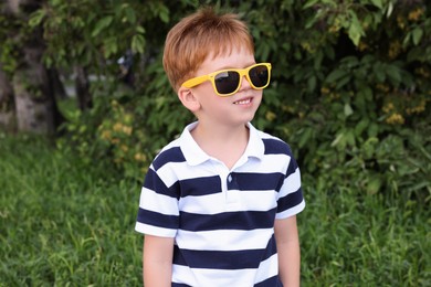 Photo of Cute little boy with sunglasses in park
