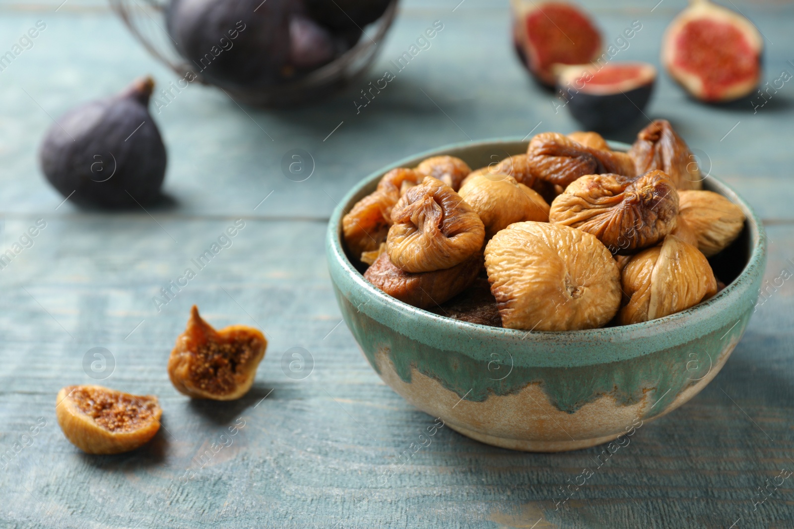 Photo of Bowl with delicious dried figs on wooden table. Organic snack