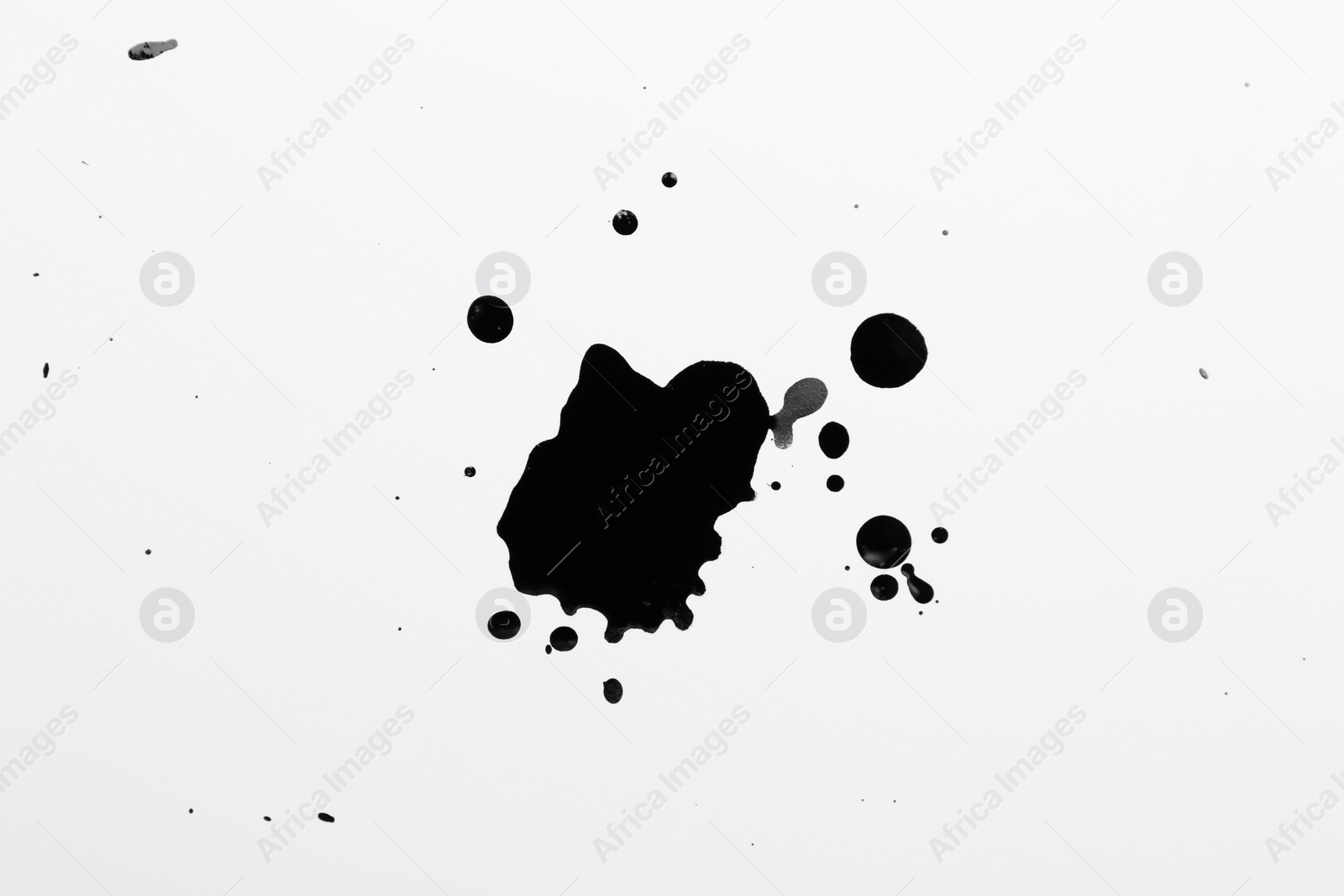 Photo of Blots of black ink on white background, top view