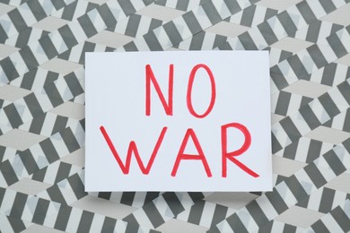 Photo of Card with phrase No War and adhesive tape on light background, top view