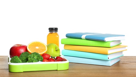 Tray with healthy food and notebooks on table against white background. School lunch