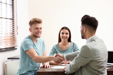 Photo of Insurance agent shaking hands with client in office