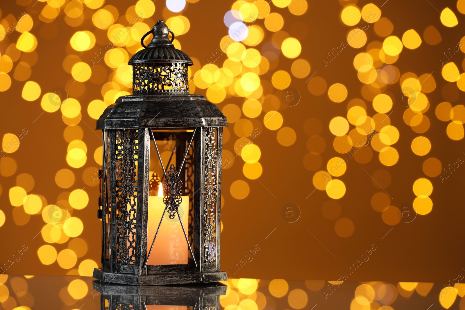 Photo of Arabic lantern on mirror surface against blurred lights, space for text