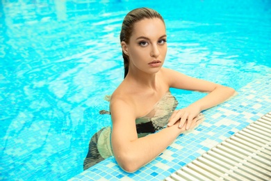 Photo of Portrait of beautiful young woman in swimming pool
