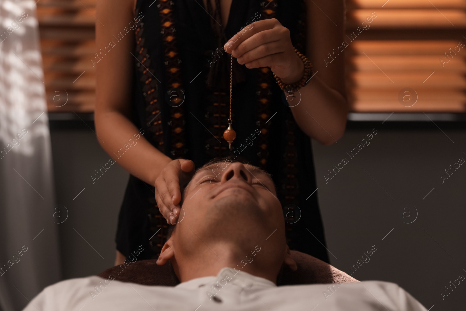 Photo of Man at crystal healing session in dark room