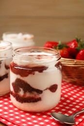 Photo of Tasty yoghurt with jam and strawberries on table, closeup