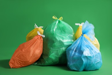 Photo of Trash bags full of garbage on green background