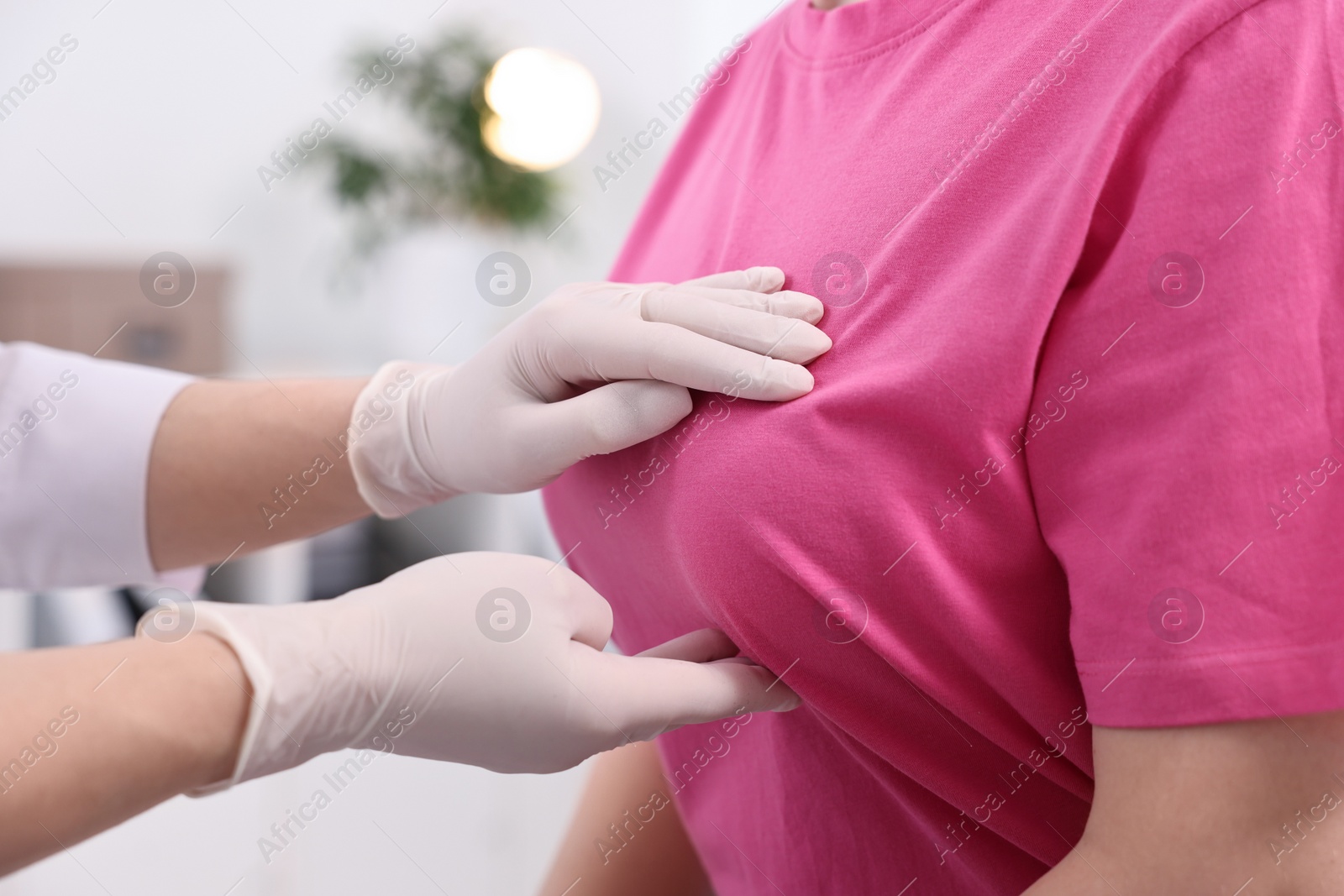 Photo of Mammologist checking woman's breast in hospital, closeup