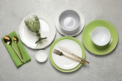 Photo of Beautiful ceramic dishware, glass and cutlery on light grey table, flat lay