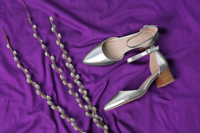 Photo of Pair of female shoes on purple fabric, top view