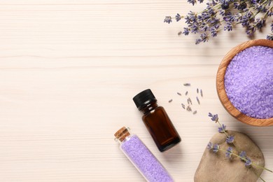 Bowl of sea salt, essential oil and lavender flowers on white wooden table, flat lay. Space for text