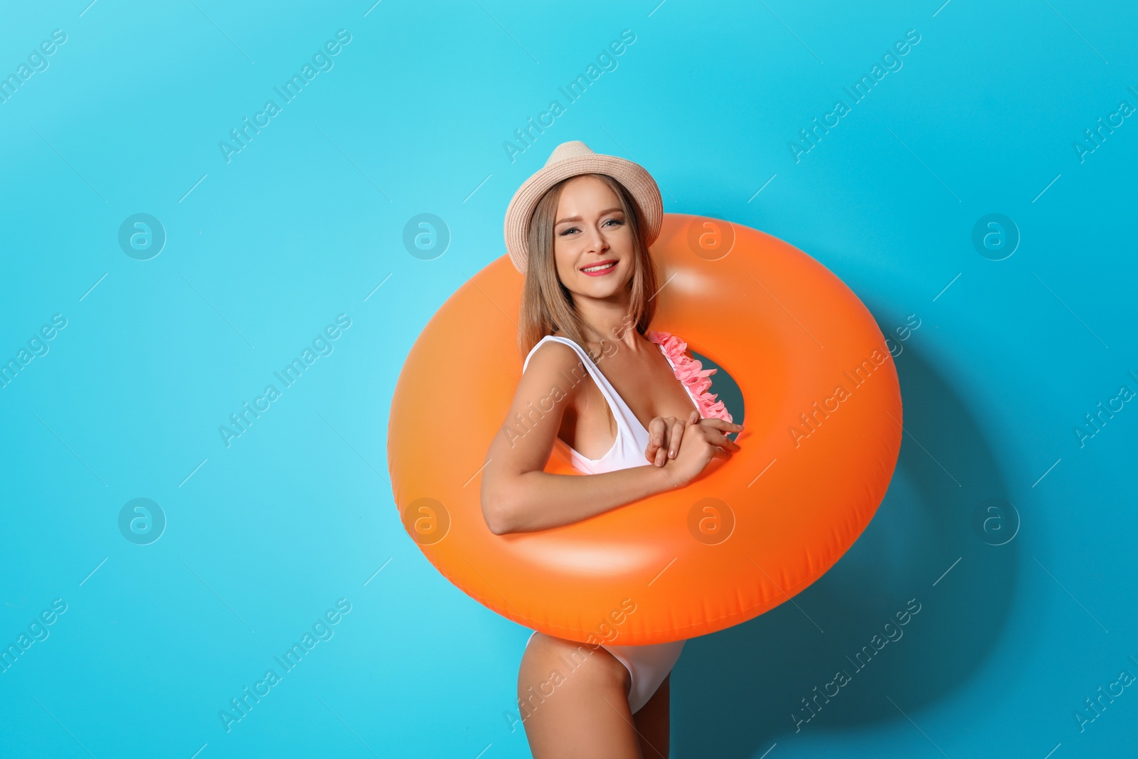 Photo of Sexy young woman in bikini with inflatable ring on color background