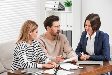 Couple consulting with professional notary in office