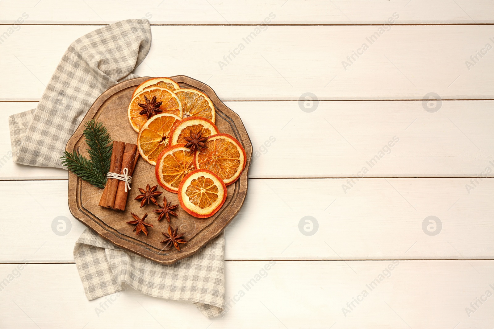 Photo of Flat lay composition with dry orange slices, anise stars and cinnamon sticks on white wooden table. Space for text