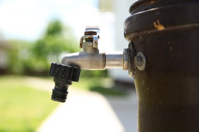 Photo of Metal water tap outdoors on sunny day