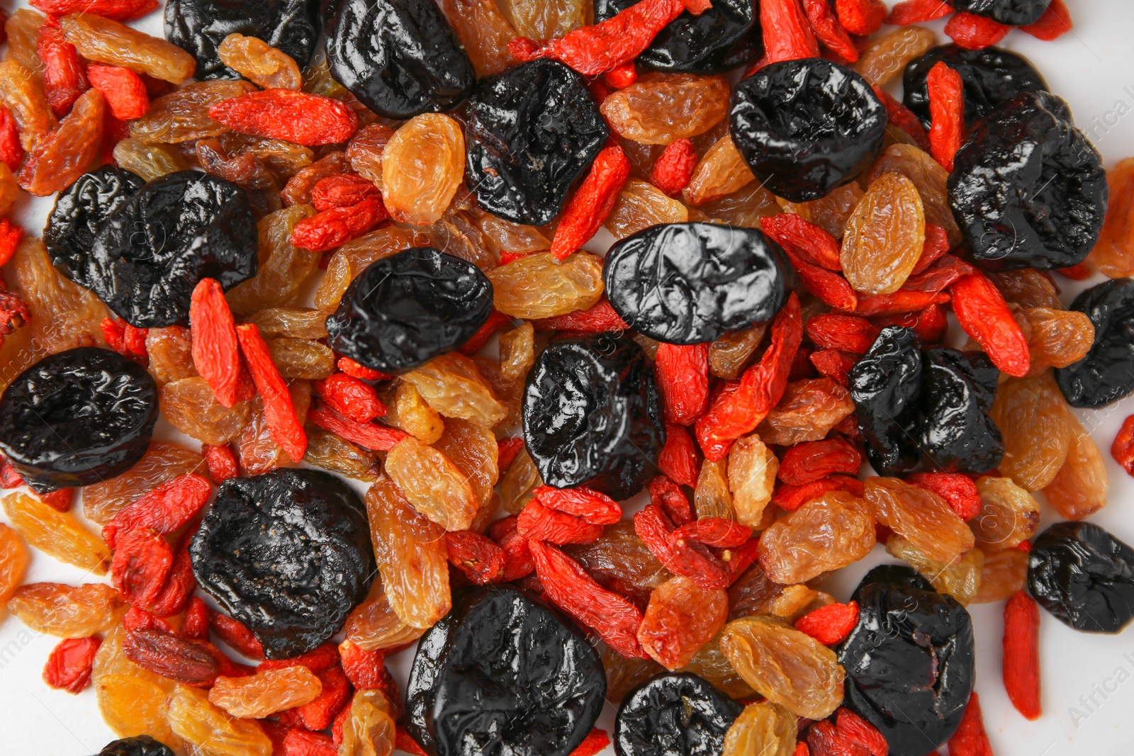 Photo of Pile of different tasty dried fruits on white background, top view