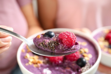 Photo of Women with tasty natural acai smoothie, closeup