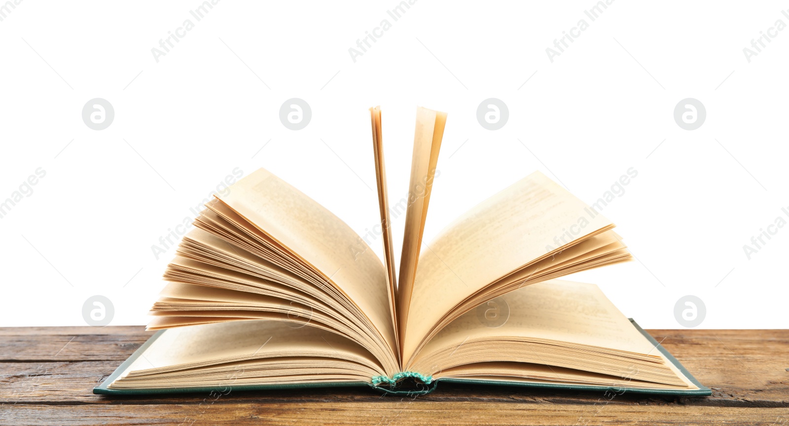 Photo of Open book on wooden table against white background