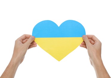 Man holding paper heart in colors of Ukrainian flag on white background, closeup