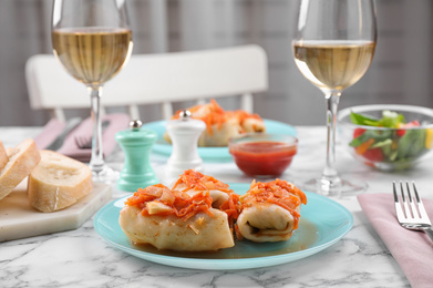 Photo of Delicious cabbage rolls served on white marble table indoors. Space for text