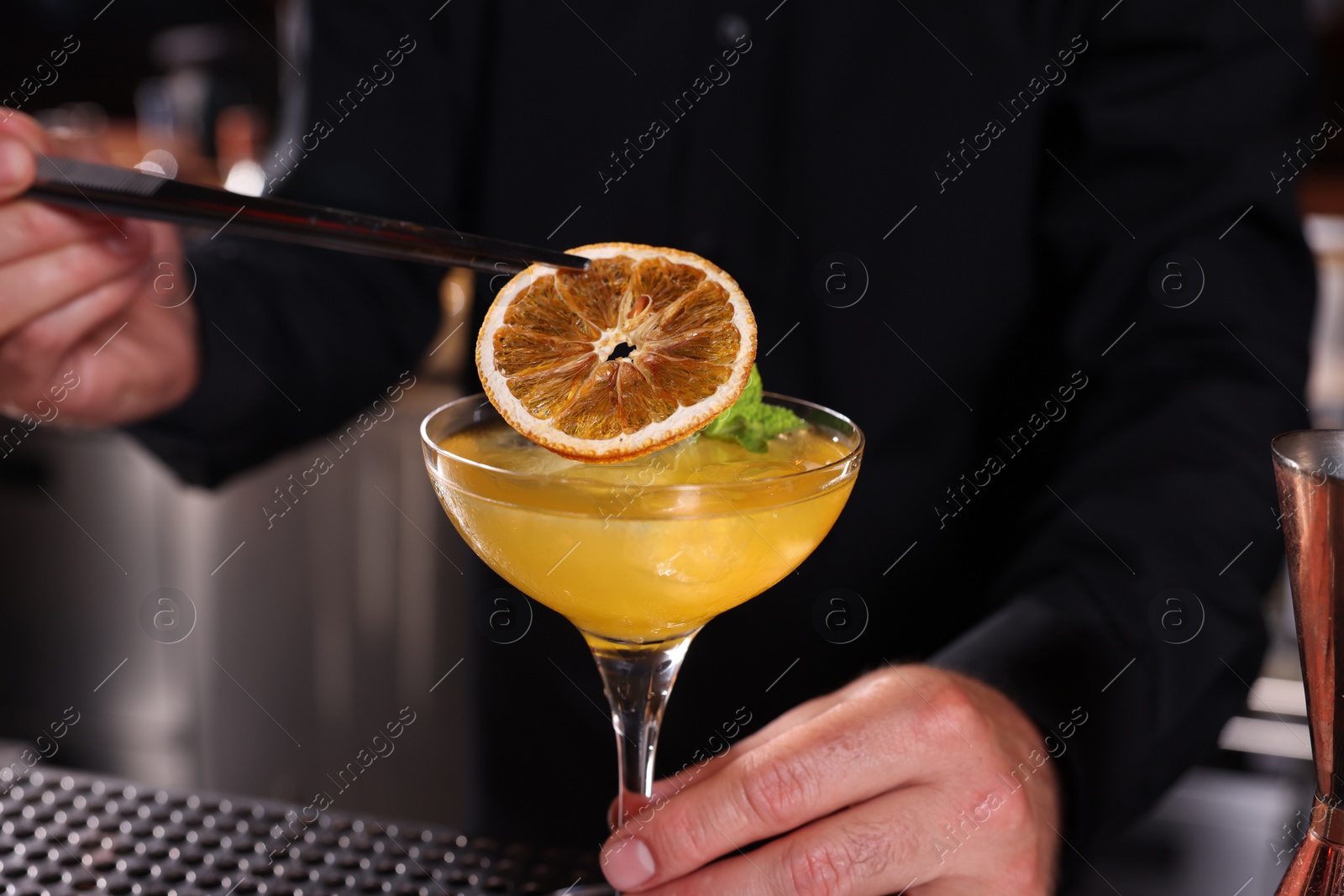 Photo of Bartender preparing fresh alcoholic cocktail in bar, closeup