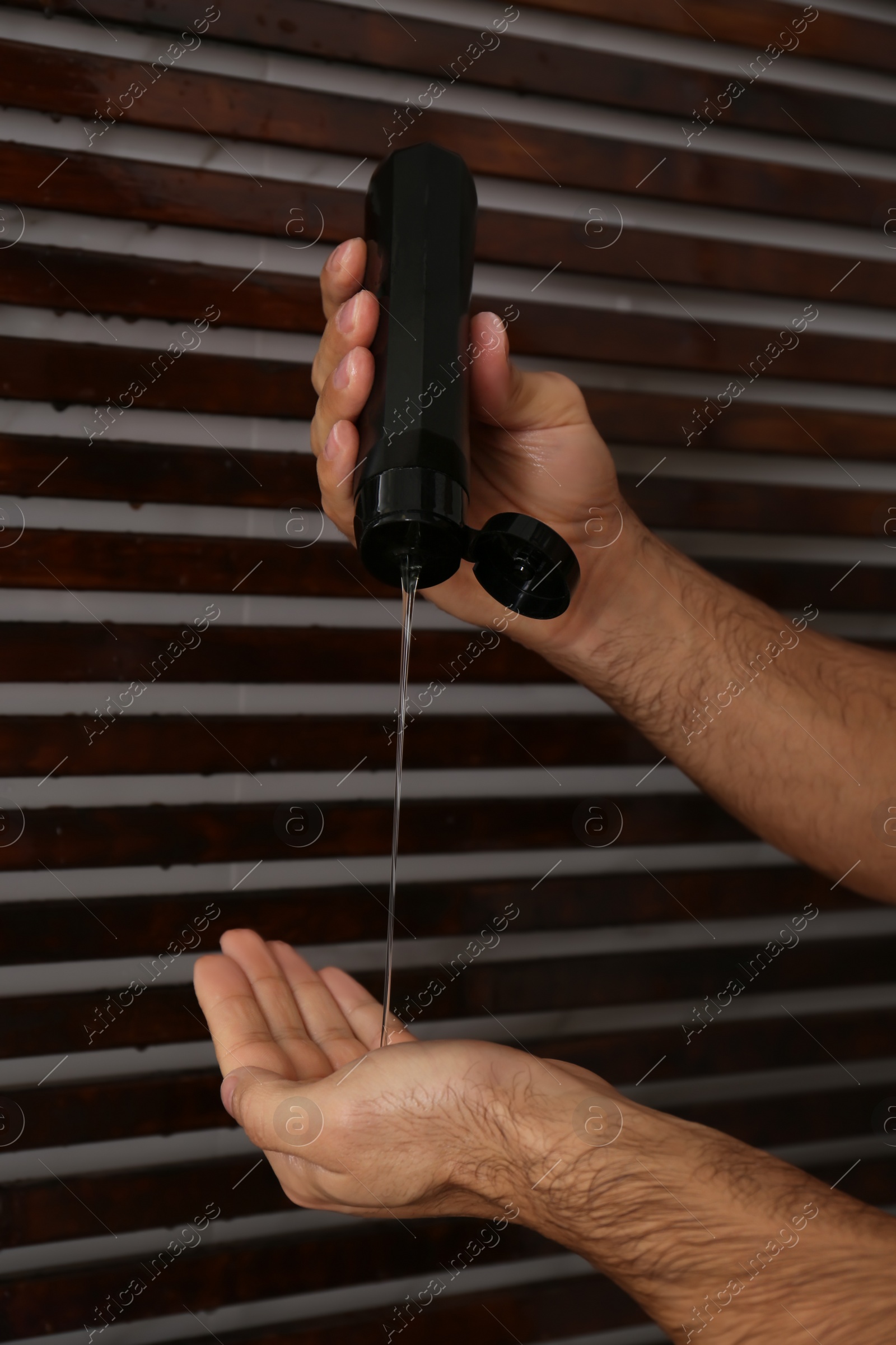 Photo of Man applying gel in shower at home, closeup