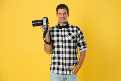 Professional photographer working on yellow background in studio