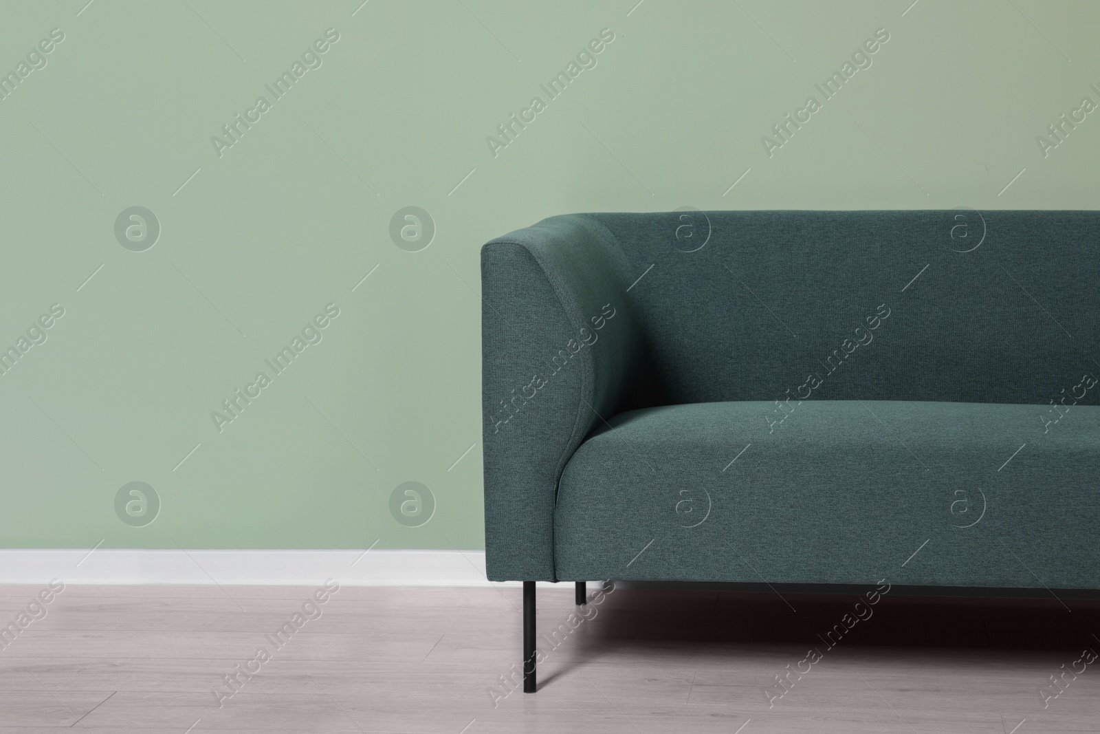 Photo of Comfortable sofa near light green wall indoors