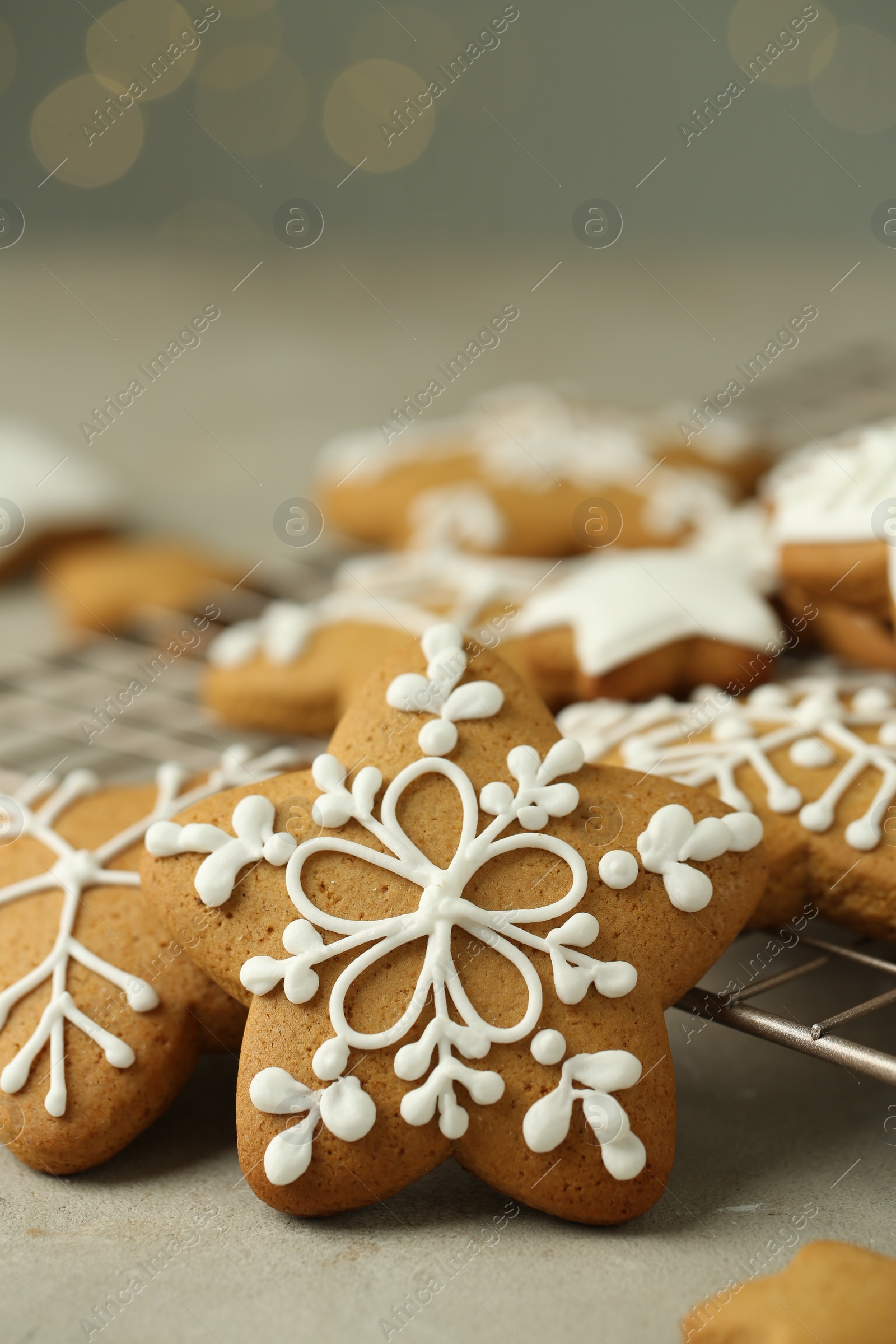 Photo of Tasty Christmas cookies with icing on table against blurred lights, closeup