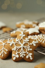 Photo of Tasty Christmas cookies with icing on table against blurred lights, closeup