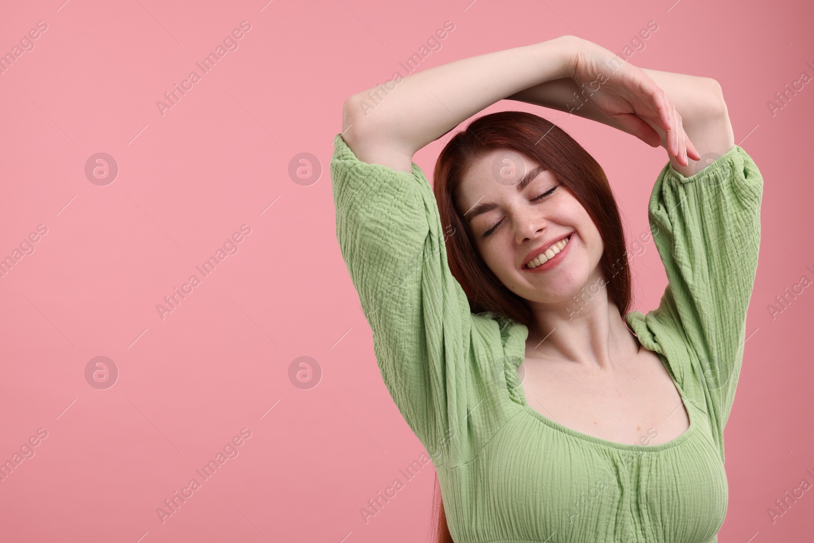 Photo of Portrait of smiling woman with freckles on pink background. Space for text