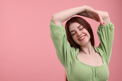 Portrait of smiling woman with freckles on pink background. Space for text