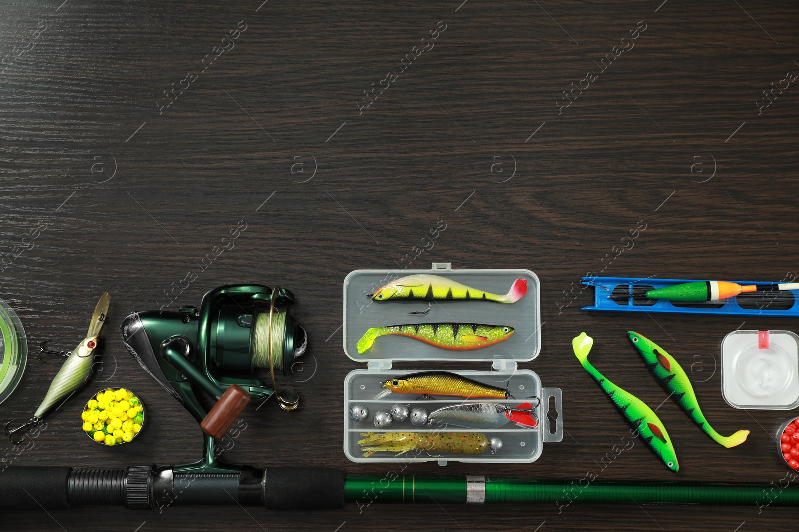Photo of Fishing tackle on dark wooden background, flat lay. Space for text