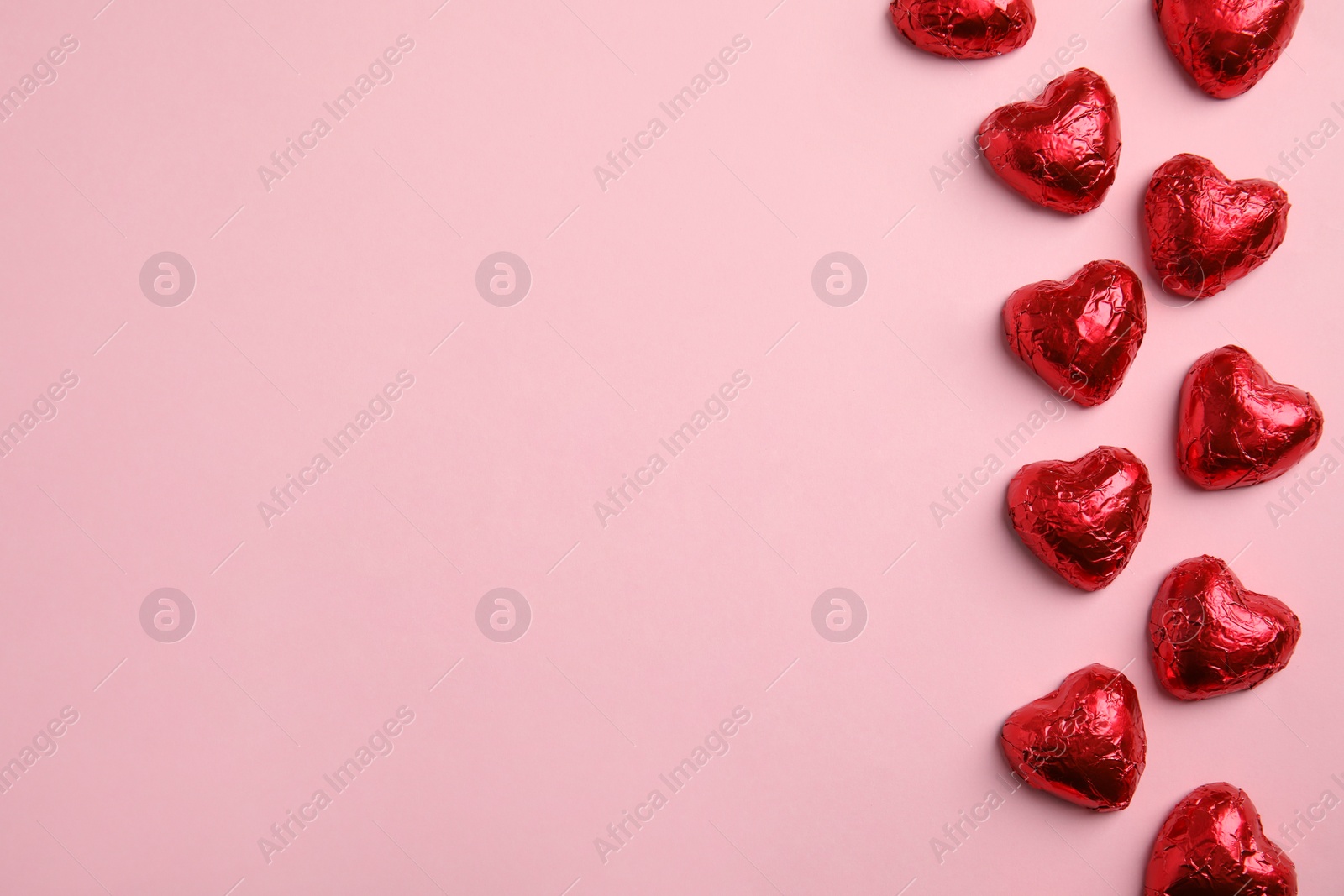 Photo of Heart shaped chocolate candies on pink background, flat lay with space for text. Valentine's day treat