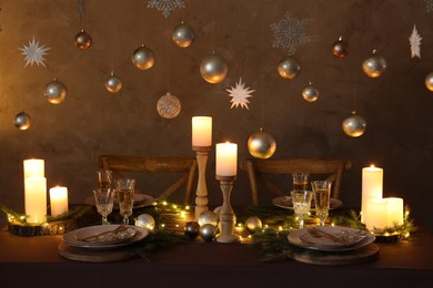 Photo of Christmas table setting with burning candles and festive decor