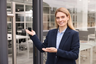 Photo of Happy real estate agent in suit inviting inside