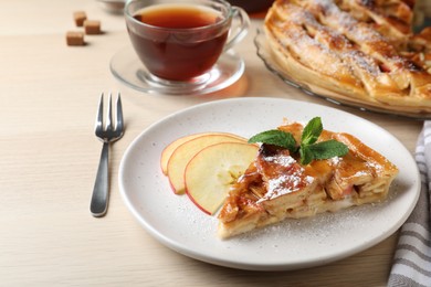 Slice of traditional apple pie served on wooden table