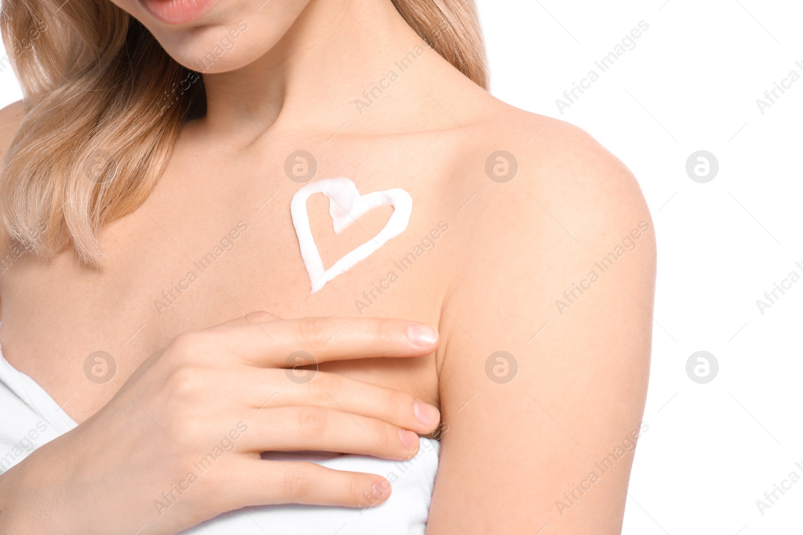Photo of Young woman with heart made of cream on her shoulder against white background, closeup. Beauty and body care