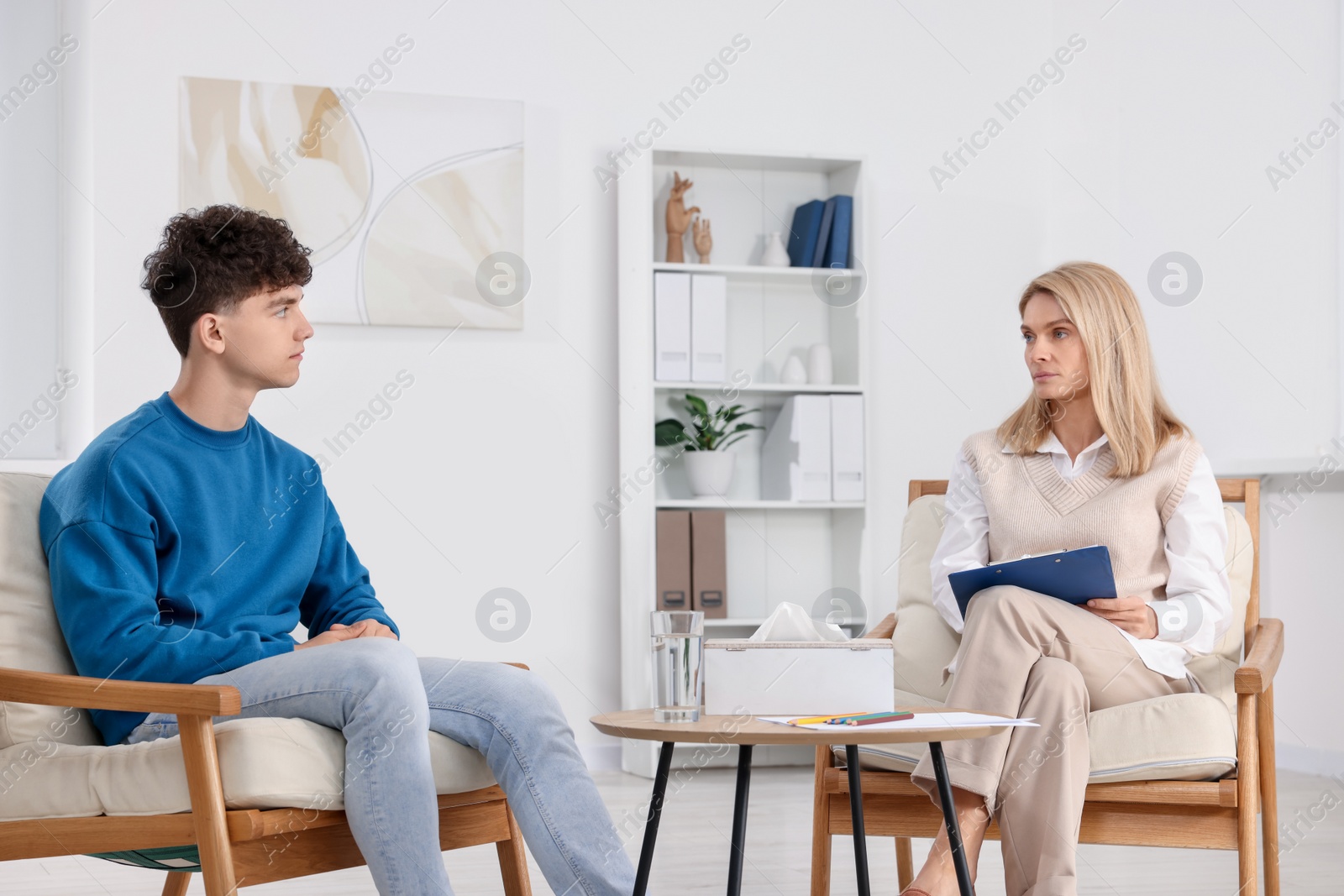 Photo of Psychologist working with teenage boy in office. Teenager problems