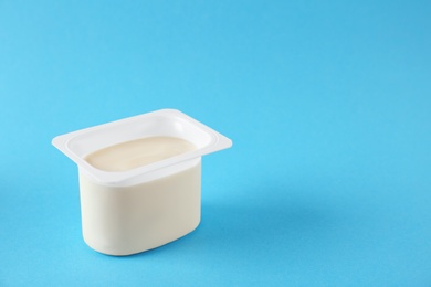 Photo of Plastic cup with tasty yogurt on color background