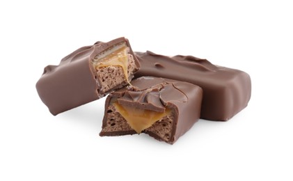 Photo of Pieces of chocolate bars with caramel on white background