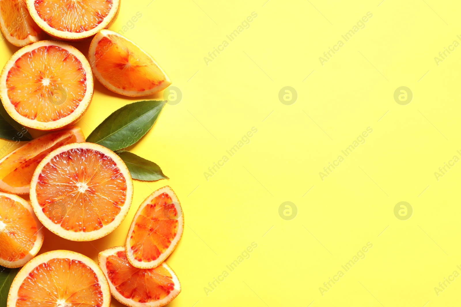 Photo of Fresh bloody oranges on color background, flat lay with space for text. Citrus fruits