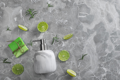 Flat lay composition with soap dispenser on grey marble background. Space for text