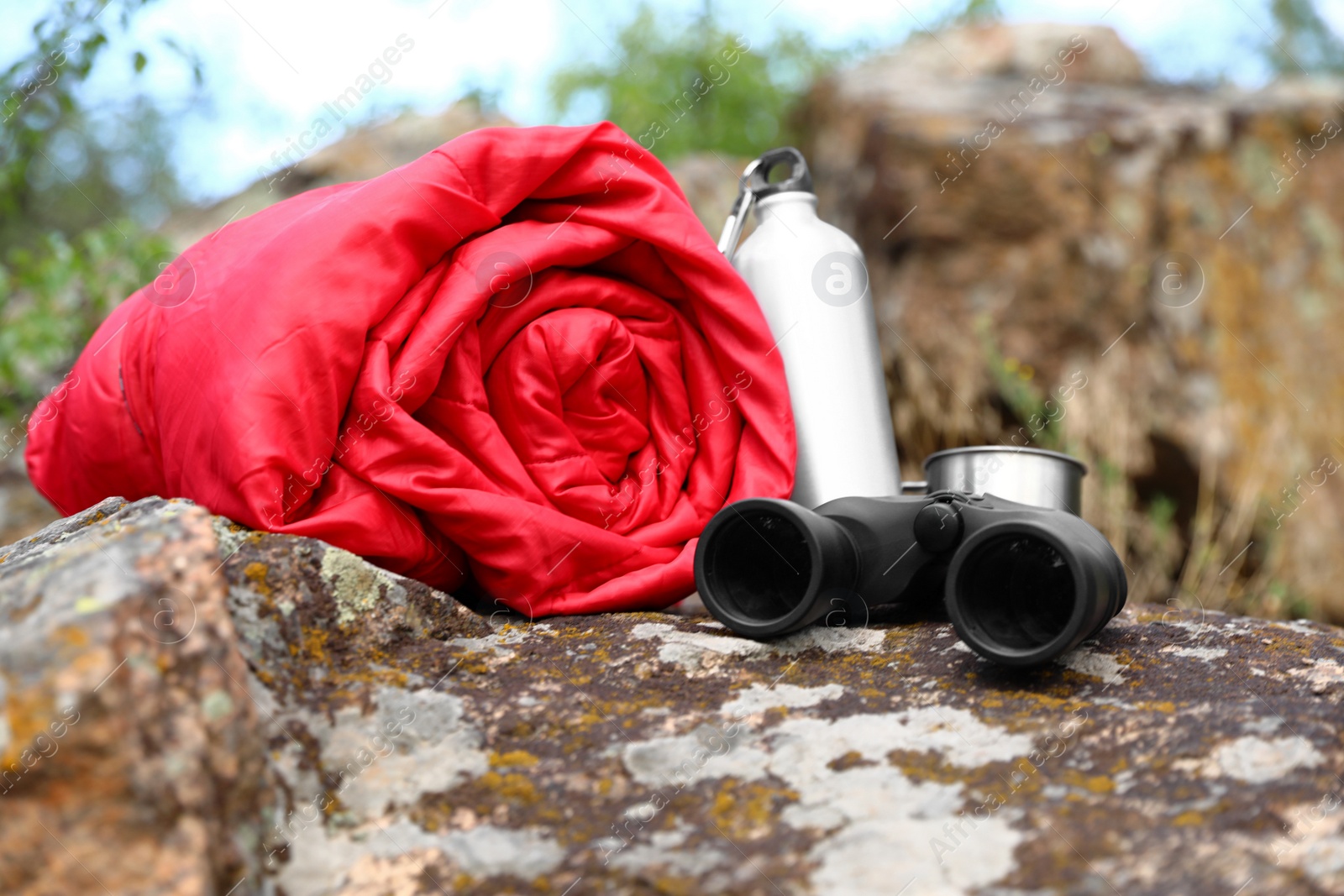 Photo of Rolled sleeping bag and other camping gear outdoors