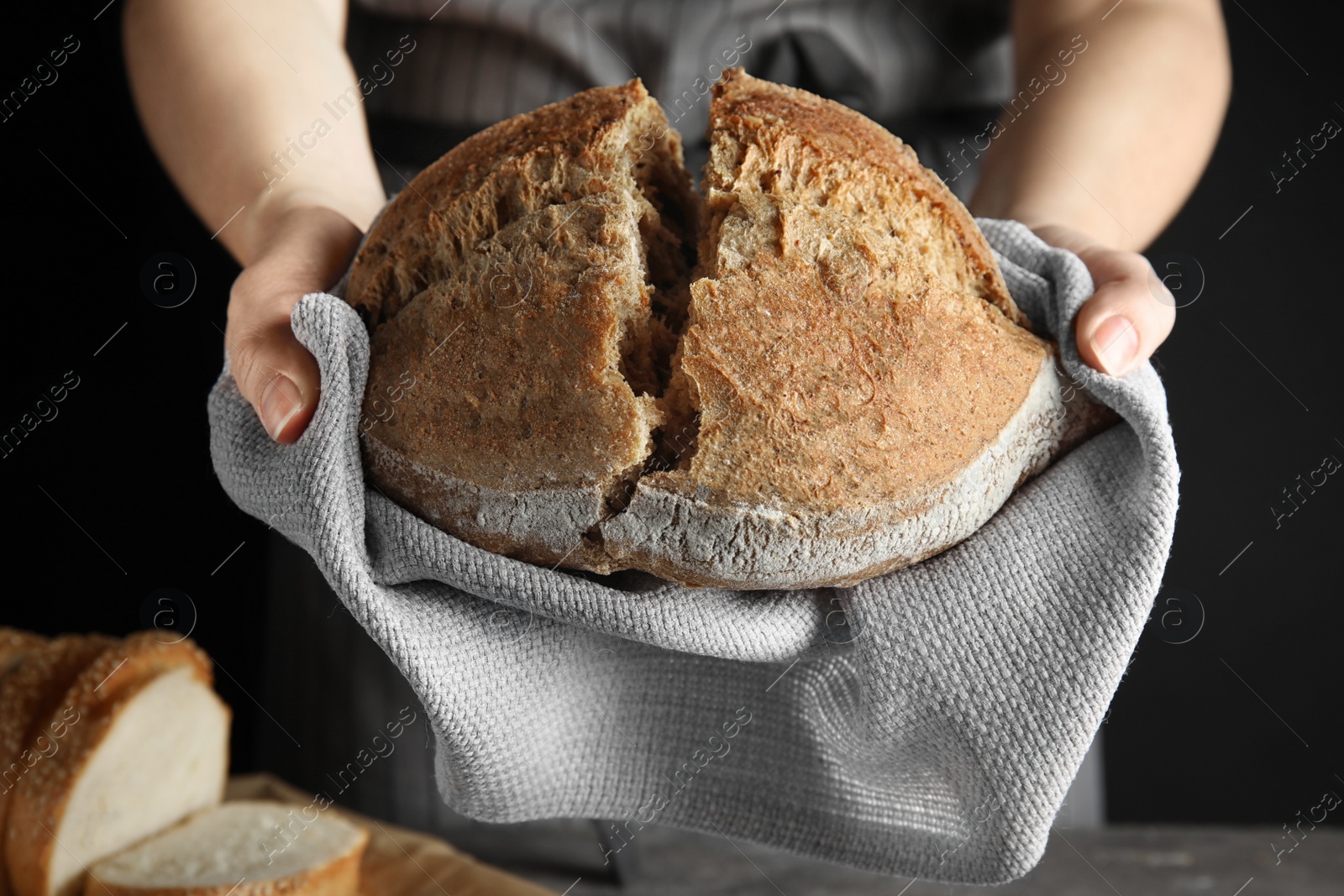 Photo of Woman holding tasty bread over table, closeup