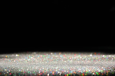 Shiny colorful glitter on black background, space for text. Bokeh effect