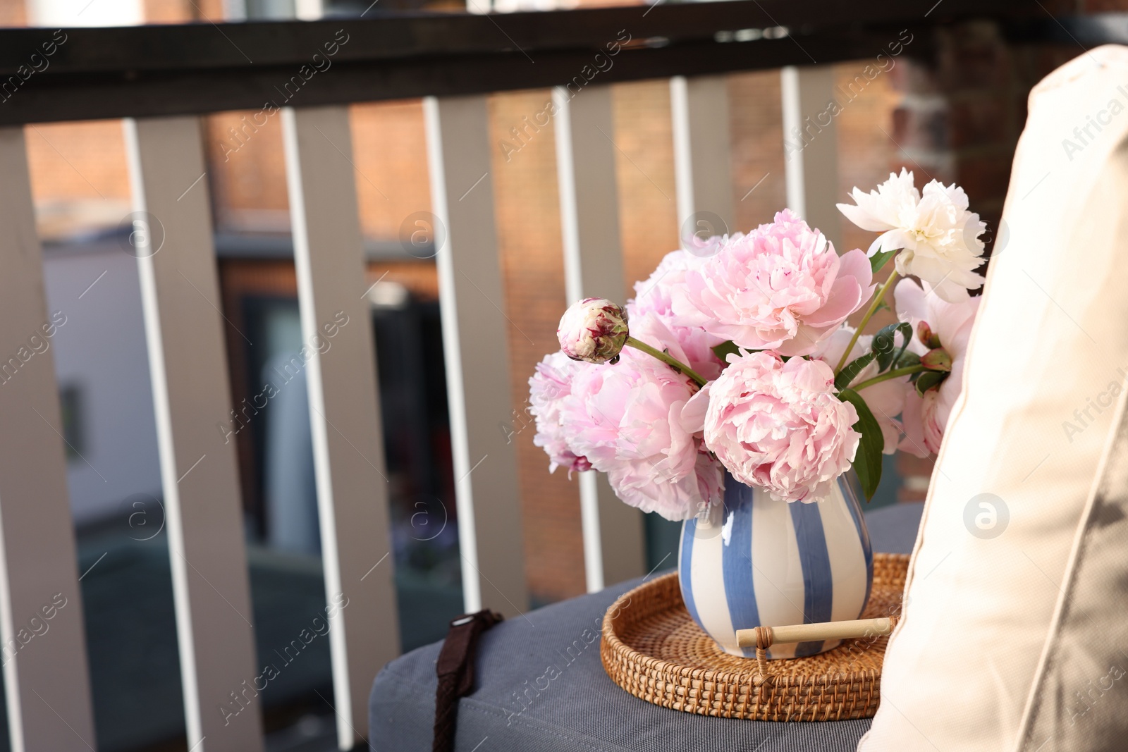 Photo of Beautiful pink peony flowers in vase at balcony. Space for text