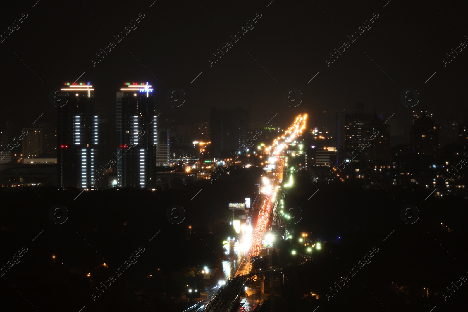 Photo of KYIV, UKRAINE - MAY 22, 2019: View of night city with apartment complex Soniachna Riviera and Metropolitan Andrey Sheptytsky Street
