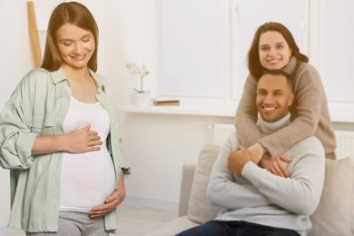 Image of Surrogate mother and intended parents in room