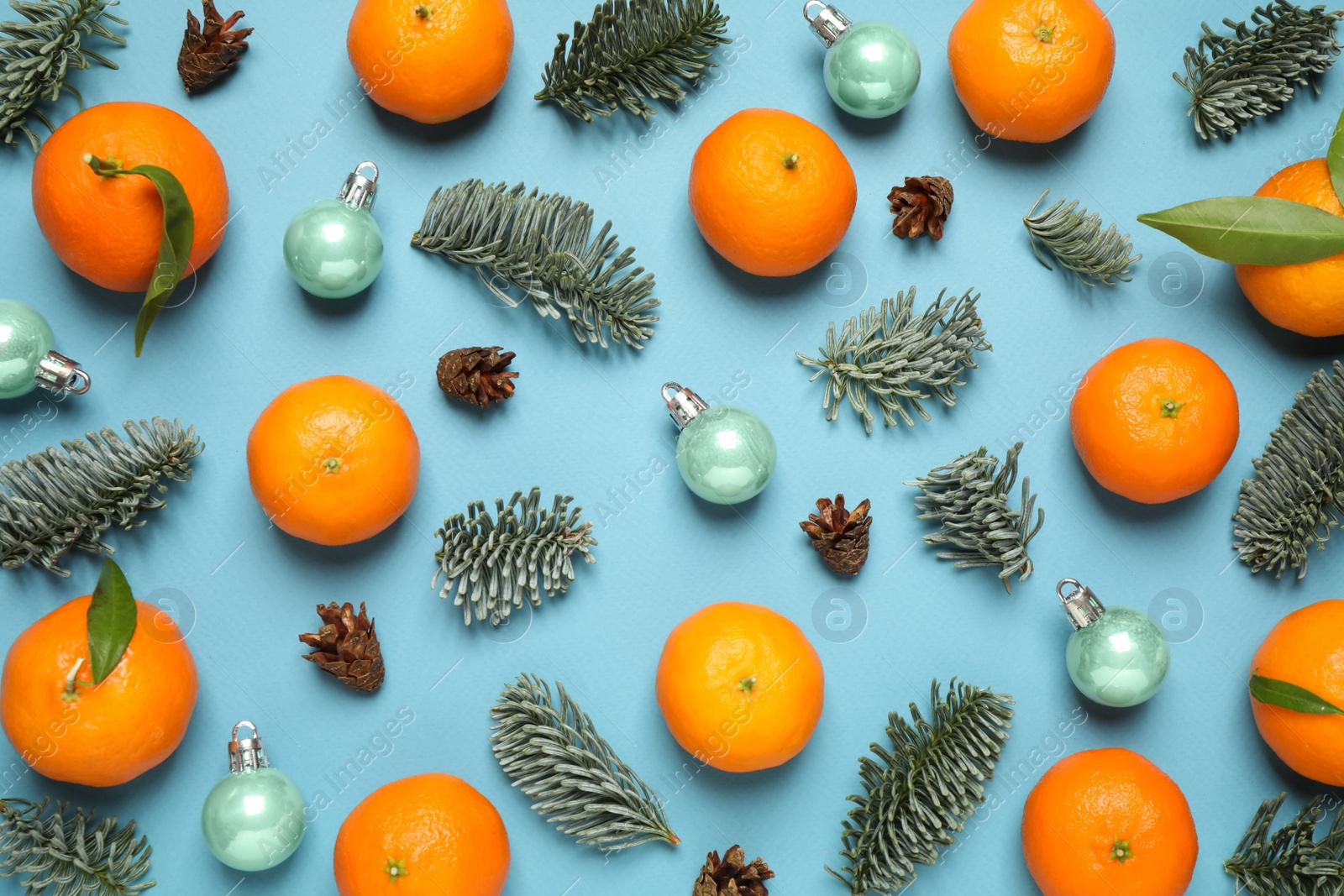 Photo of Composition with Christmas balls and tangerines on light blue background, flat lay